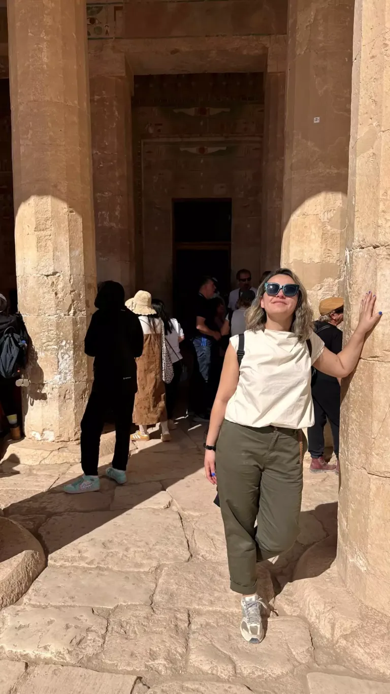 Mujer apoyada en una columna de piedra